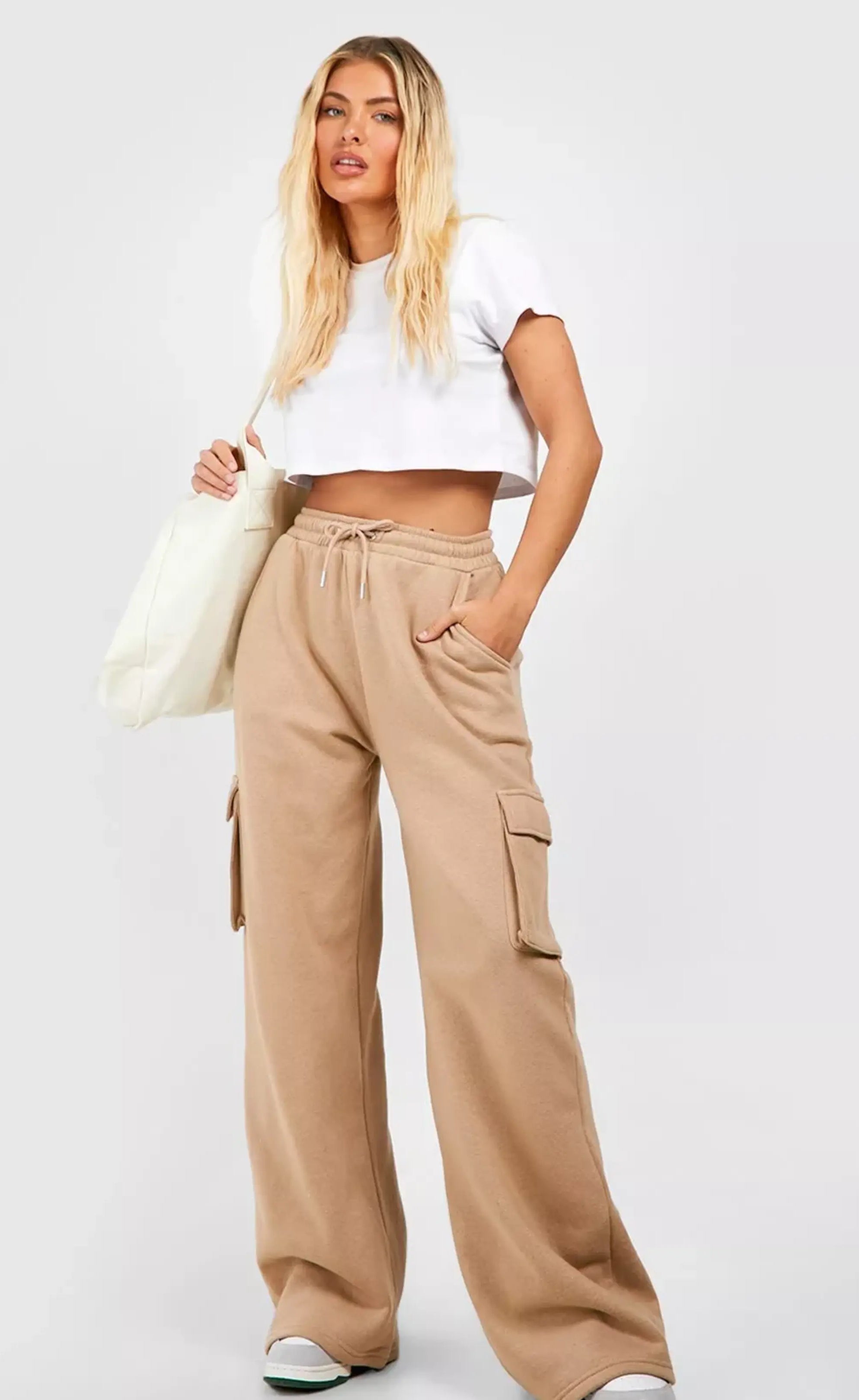 "A photo of a woman wearing comfortable, wide-leg tan cargo pants with a drawstring waist and side pockets. The pants are made of a soft, stretchy fabric and are perfect for casual wear."