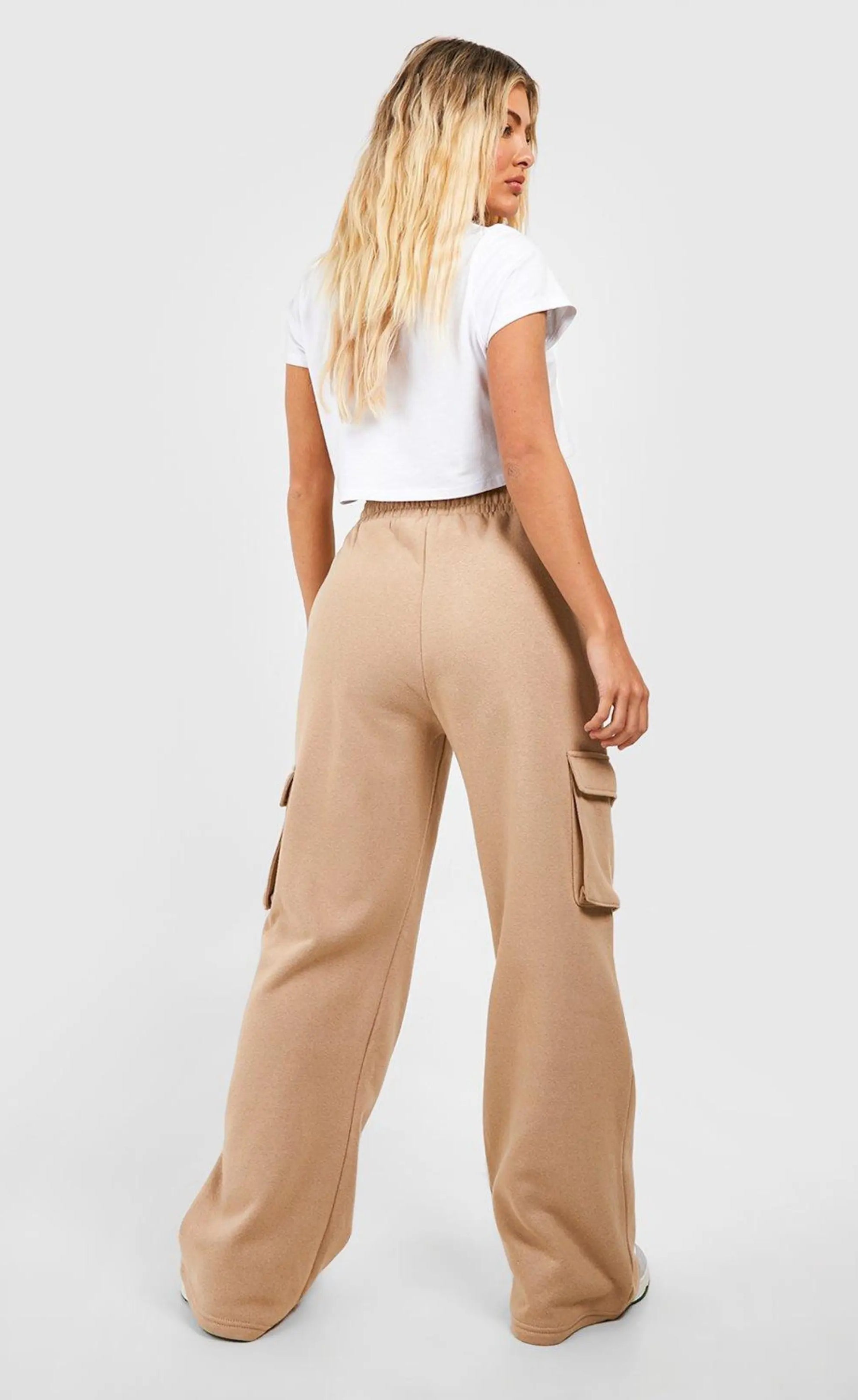 "A photo of a woman wearing comfortable, wide-leg tan cargo pants with a drawstring waist and side pockets. The pants are made of a soft, stretchy fabric and are perfect for casual wear."